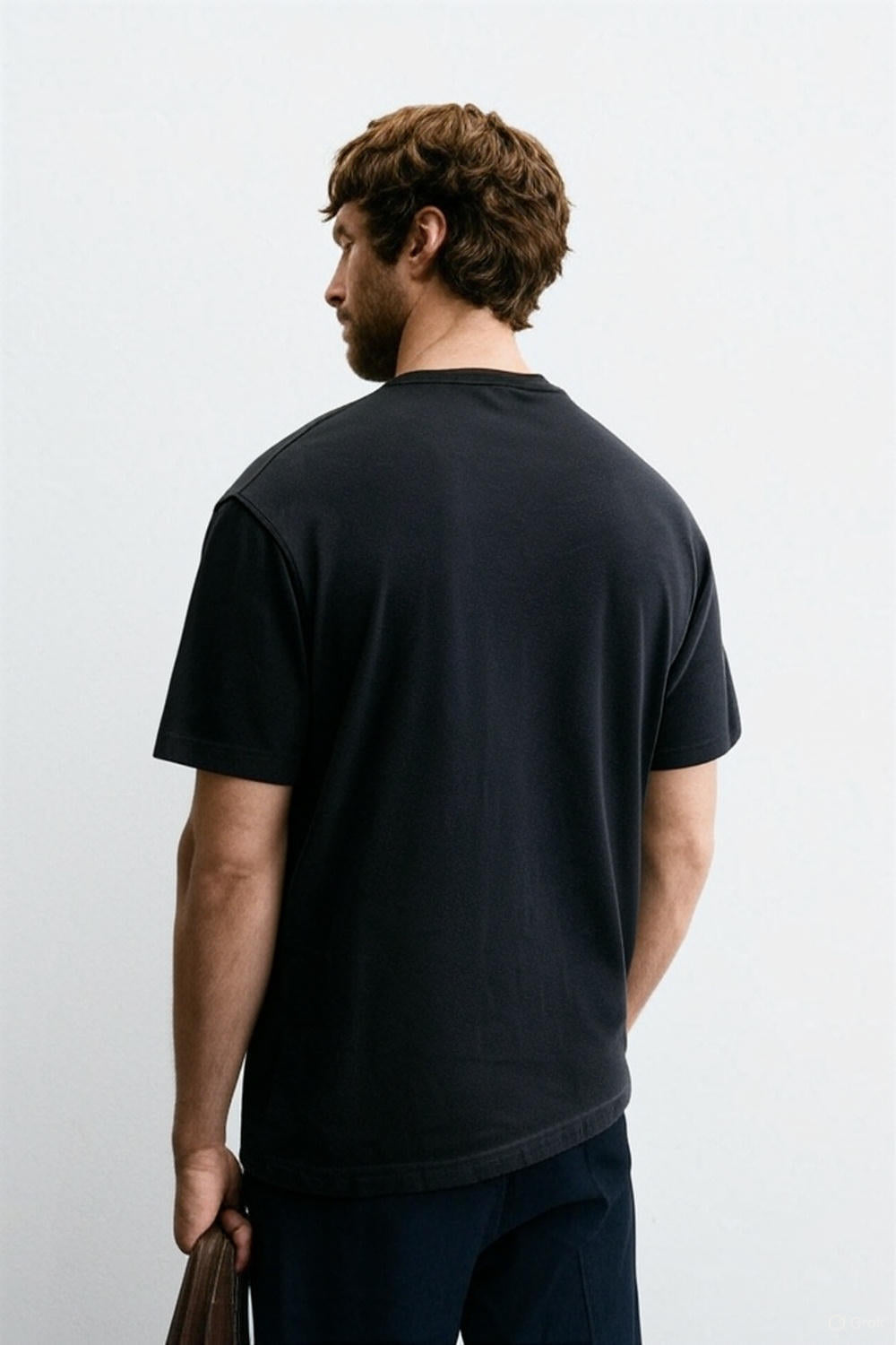 Man wearing a black t-shirt against a plain background