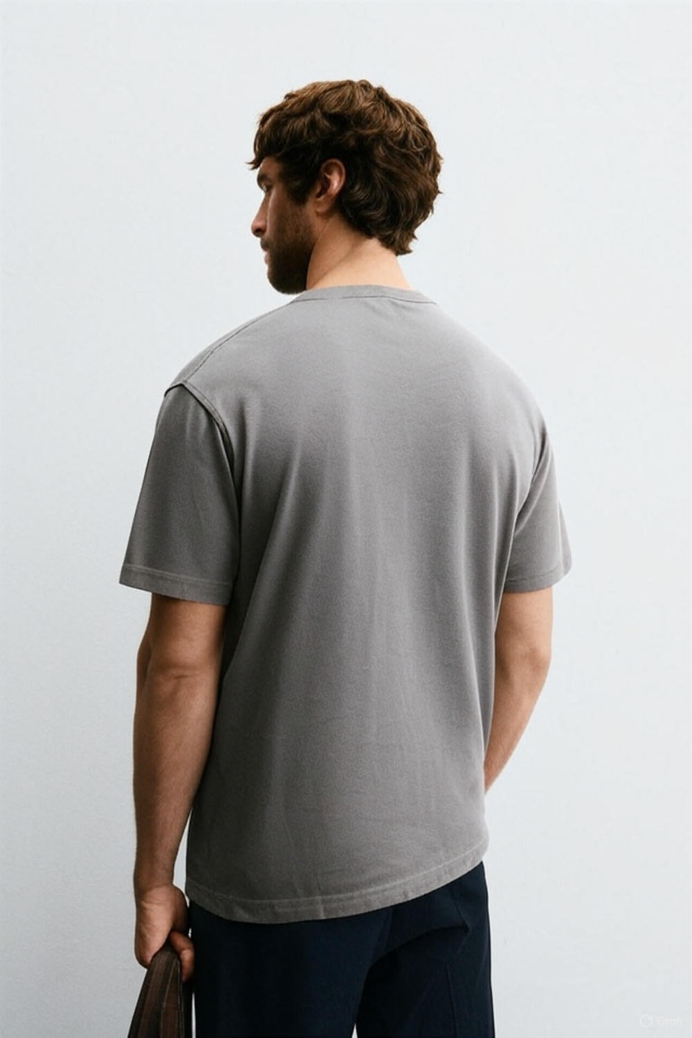 Man wearing a gray t-shirt against a white background